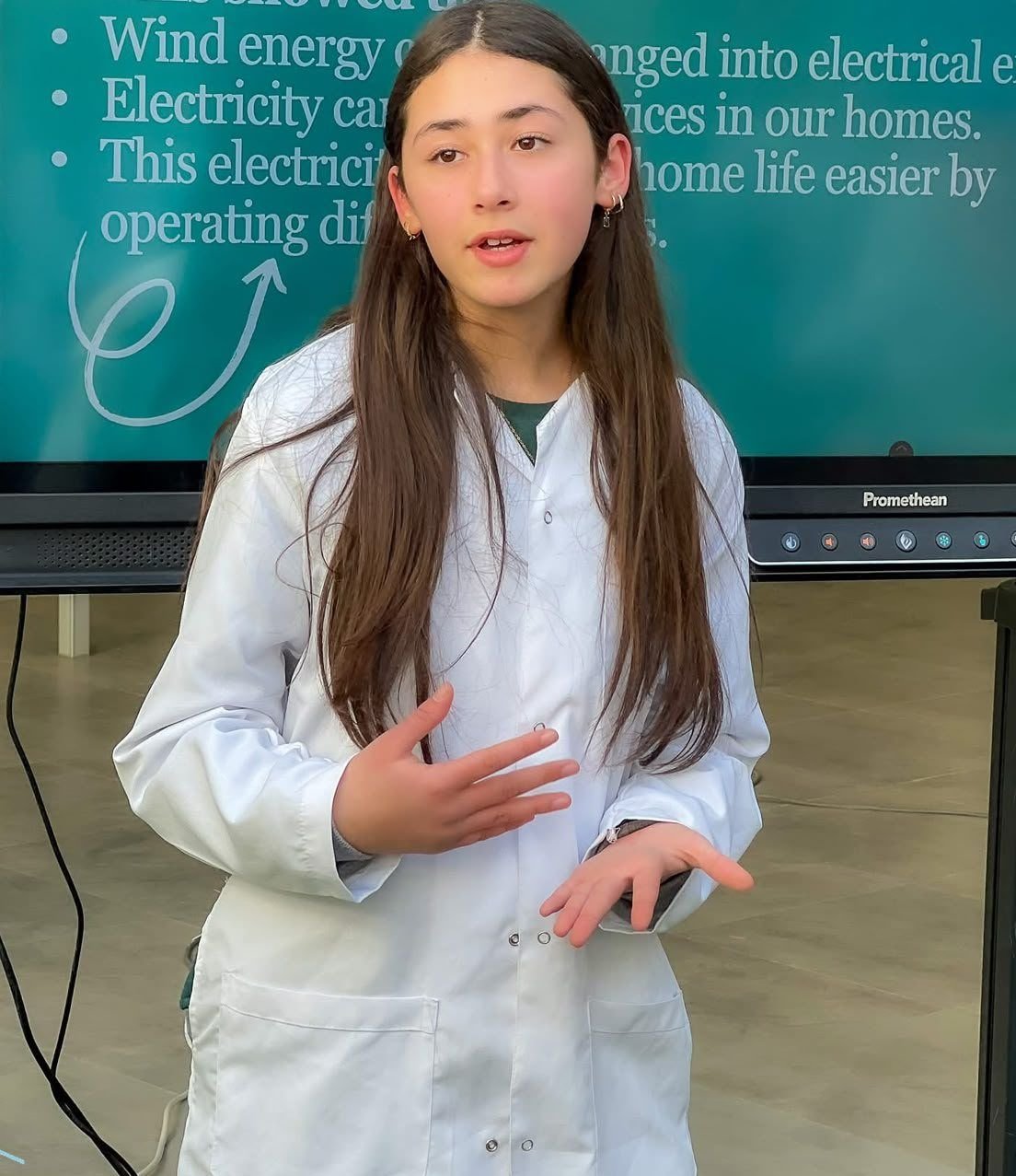 Student presenting a science project in a lab coat