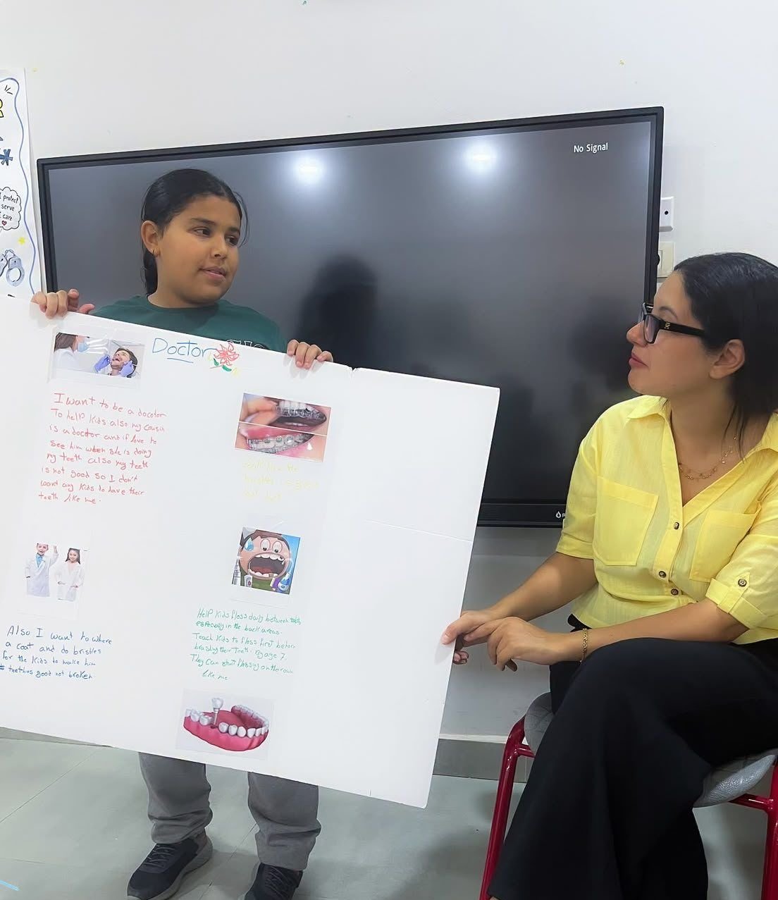 Student presenting a poster to her teacher